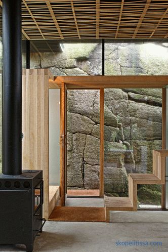 Hiša s prozornimi stenami na sončnih kamnitih obalah v Sandefjordu na Norveškem