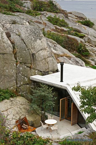 Hiša s prozornimi stenami na sončnih kamnitih obalah v Sandefjordu na Norveškem